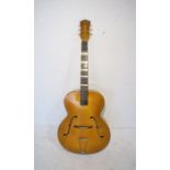 A vintage Triumph six string acoustic guitar.
