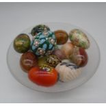 A collection of decorative eggs in glass bowl