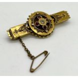 A Victorian 15ct gold brooch set with with a central diamond and four rubies, total weight 5.8g