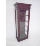 A turn of the century shop display cabinet with four glass shelves.