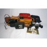 A small collection of vintage cameras and equipment including a Nikon Nikkormat with instruction