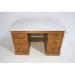 An antique pine kneehole desk with marble top (repaired), length 127cm, height 78cm, depth 67cm.