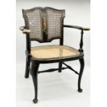 An antique small black lacquered and chinoiserie decorated cane-panelled armchair