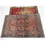 Two eastern red ground rugs. Overall sizes 71cm x 114cm and 55cm x 100cm.