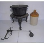 A cast iron cooking pot on trivet stand along with a stoneware jar from Mitchell Toms & Co Ltd,