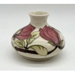 A Moorcroft magnolia vase of squat form impressed and painted marks to the base numbered 74/100 -