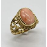 A 9ct gold ring with pierced decoration to shoulders set with coral
