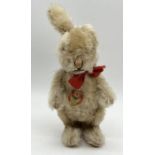 A Steiff Niki rabbit with mohair fur, stitched nose, silver button to ear and original tag