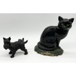 A cast iron doorstop in the form of a black cat along with another in the form of a terrier