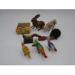 A collection of vintage clockwork tinplate toys in the form of animals including West German