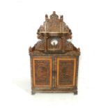 A 20th century heavily carved Chinese cabinet with traditional scenes to pierced decoration. The