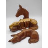 A carved wooden figure of a sleeping dog (approx. 36cm) along with a smaller version and mounted