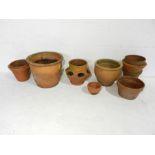 A quantity of terracotta garden pots including a strawberry pot