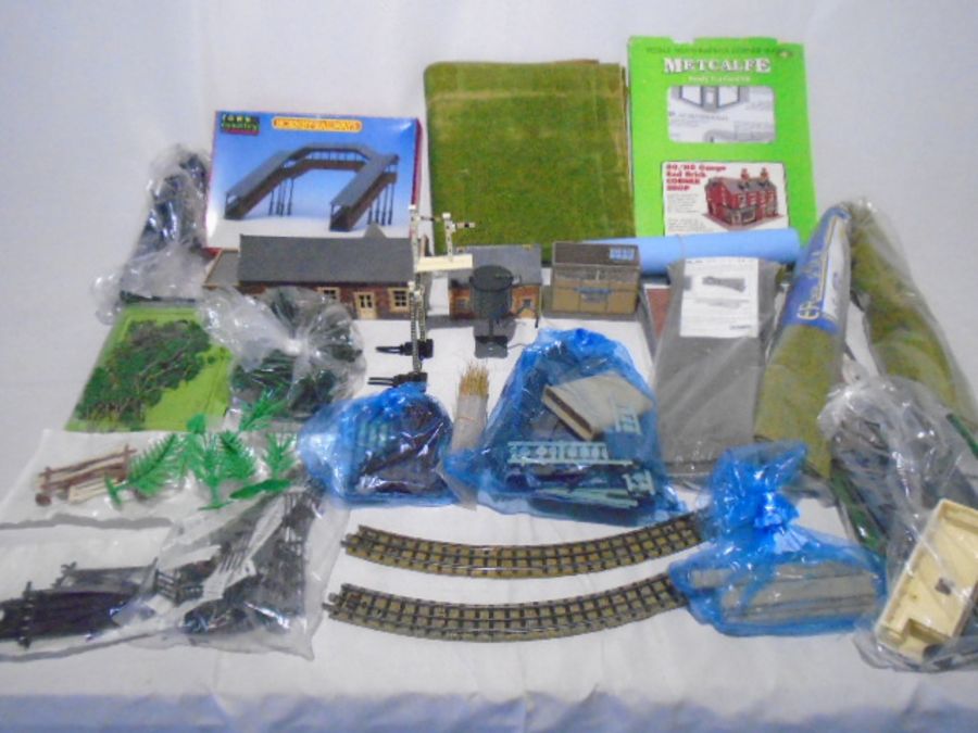 A collection of various model railway accessories and scenery including buildings, trees, signals,