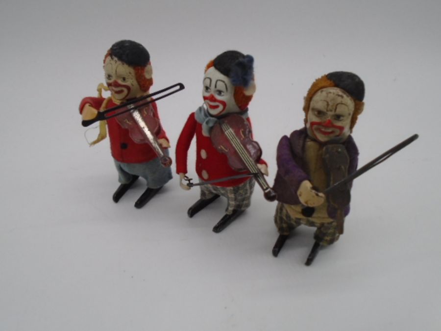 Three vintage Schuco clockwork tinplate toys in the form of clowns playing the violin (one with an