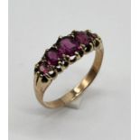 An unmarked gold garnet five stone ring