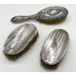 A hallmarked silver dressing table brush along with two silver clothes brushes