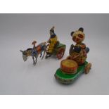 Two clockwork tinplate models including one of a clown on a horse drawn cart and a panda drumming