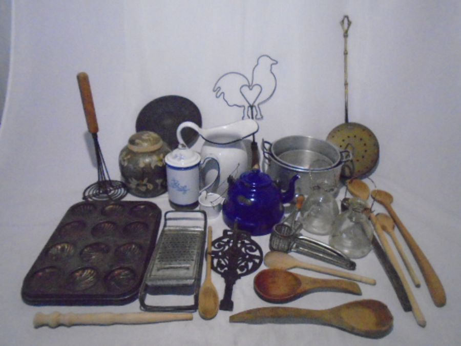 A collection of vintage kitchenalia including enamelled jugs, kettle, wooden spoons, pans,
