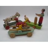 Three vintage wooden pull-along toys including spotty dog, bird on ski's and hen feeding