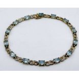 A 9ct gold tennis style bracelet set with aquamarines and diamonds