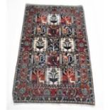 An Eastern red ground rug with animal design - overall size 182cm x 120cm