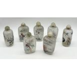 A collection of Chinese snuff bottles with various designs including pandas, cranes etc