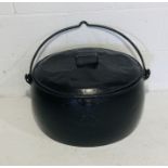 A vintage cast iron lidded cauldron