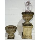 A Sandford Stone garden urn on plinth along with a smaller matching urn - height of tallest 82cm