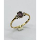 A 9ct gold three stone ring set with diamonds and amethyst