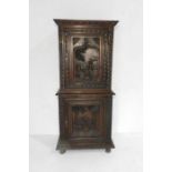 A 19th century carved oak two door cupboard, each door carved with traditional scenes - length 80cm,