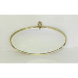 A brass framed oval wall mirror with bevel edged glass - length 76cm