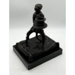 A bronze novelty candlestick depicting a monkey in costume on a cushion with marble base