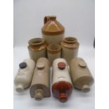 A collection of vintage stoneware jars and hot water bottles.
