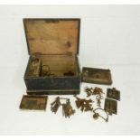 A small antique wooden trunk containing various metal door furniture, locks and keys etc.