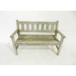 A weathered wooden slatted garden bench - length 122cm