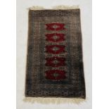 An Eastern red ground rug - overall size 96cm x 59cm