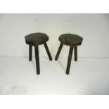 Two wooden three legged stools