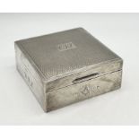 A silver cigarette box with engine turned decoration and Masonic symbol to front, dated 1968