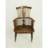 An antique Welsh comb-back chair with elm seat with hand-hold and incised decoration to back splat