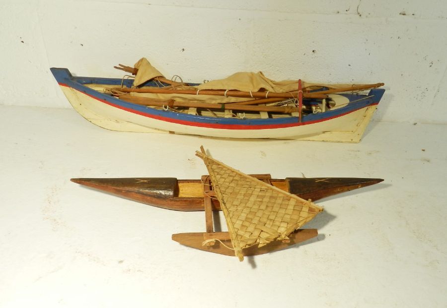 A model boat along with a tribal wooden model of an outrigger (A/F)