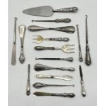 A collection of silver mounted items including button hooks, shoe horn, cake slice etc.