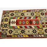 A red ground rug with geometric design - overall size 138cm x 92cm
