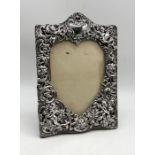 A Victorian silver photo frame decorated with putti, dragons etc, London 1898