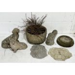 A collection of various garden ornaments along with a composite stone planter and two plaques