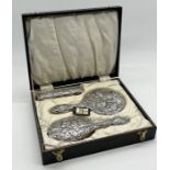 A cased hallmarked silver dressing table set consisting of mirror and two brushes