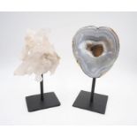 A quartz crystal specimen along with an agate, mounted on plinths