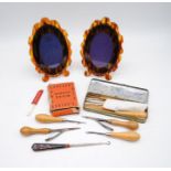 A pair of faux tortoiseshell photo frames along with a collection of sewing accessories including
