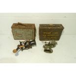 Two metal ammo boxes along with a brass bell and a 'Spong' mincer