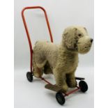 A vintage push-along dog by Lines Bros Ltd (Ireland) with mild steel frame, rubber wheels, stuffed